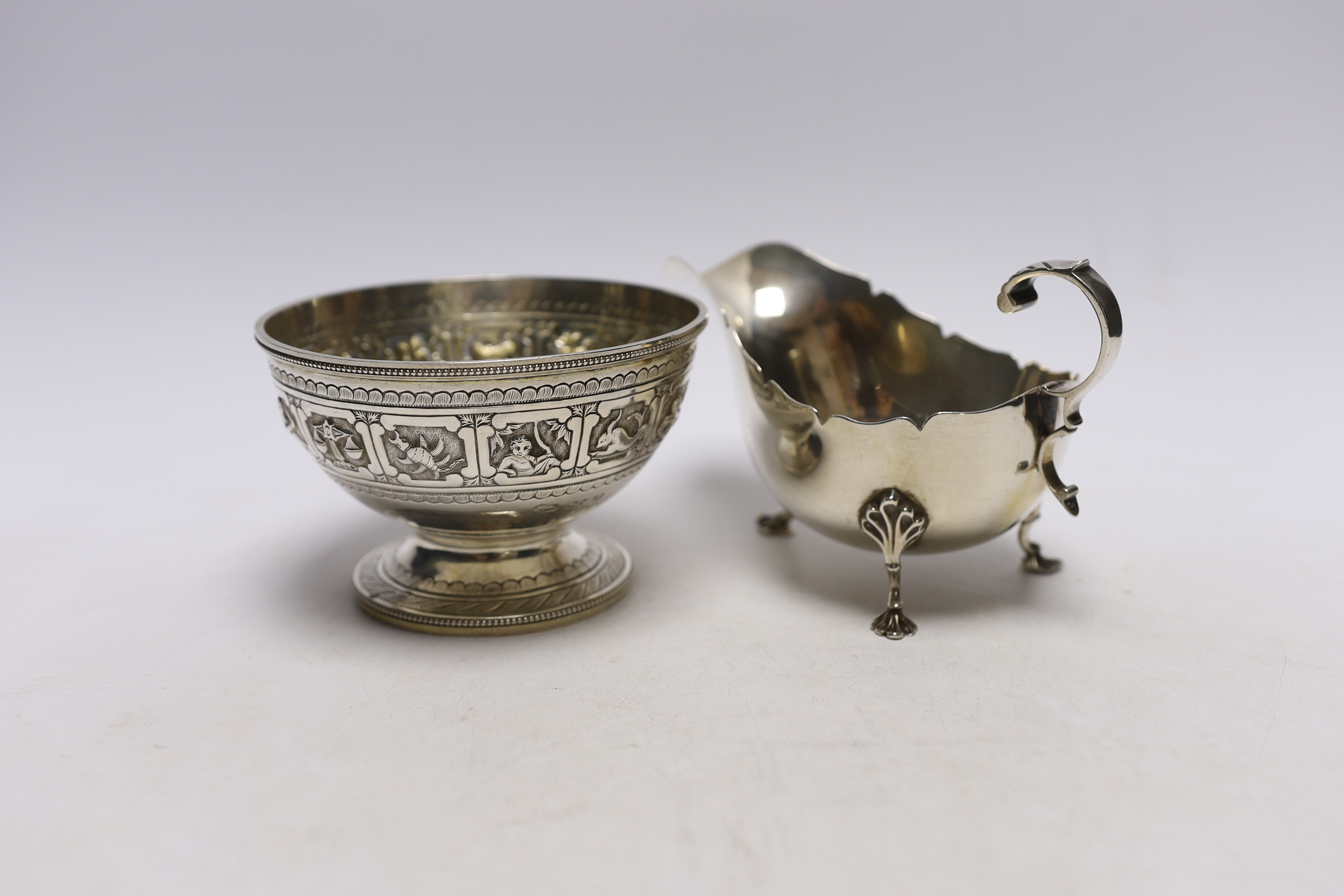 A Victorian silver 'Zodiac' pedestal bowl, by Frederick Elkington. London, 1881, diameter 12.4cm and a later silver sauceboat, 14.1oz.